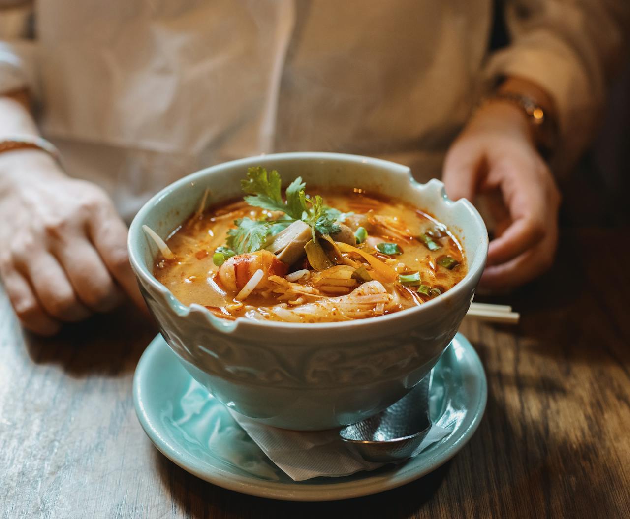 gallery-2 Delicious spicy noodle soup served in a Tokyo restaurant, garnished with fresh herbs and vegetables.